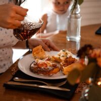 Table dressée avec tartines, carafe et bougies lors d’un repas convivial
