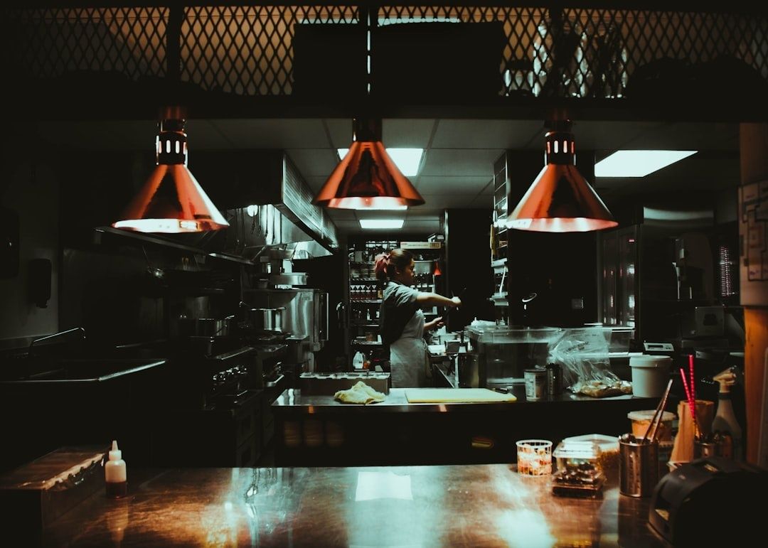 Cuisine professionnelle avec une cuisinière travaillant sous des lampes chauffantes