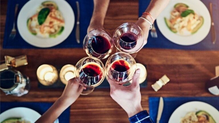 Quatre convives trinquent au vin autour d